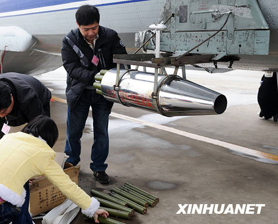 資料圖：2月8日，在河南省鄭州市新鄭機場，工作人員往飛機上裝掛人工增雨用的碘化銀催化劑。