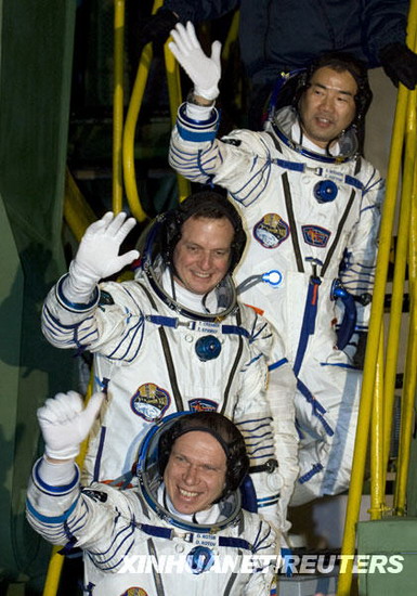 21日，在哈薩克斯坦境內的拜科努爾航天發射中心，國際空間站第22長期考察組成員俄羅斯宇航員奧列格·科托夫、美國宇航員蒂莫西·克里默和日本宇航員野口聰一（從下至上）在進入飛船前向人們揮手。